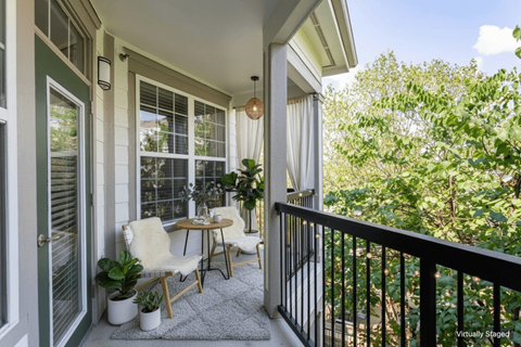 A balcony with a table and chairs.