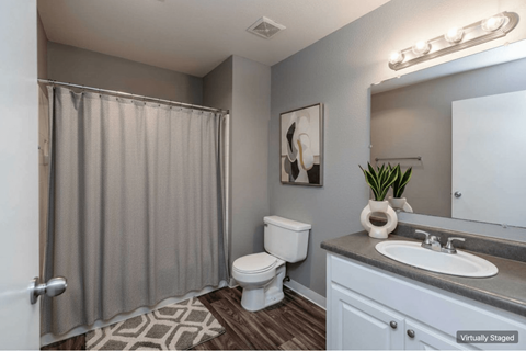 A bathroom with a toilet, sink, and shower curtain.