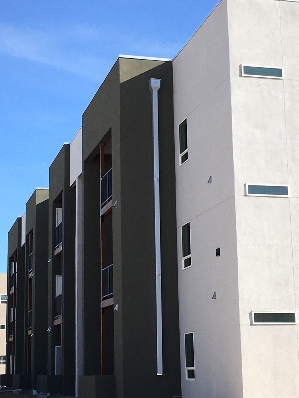 A modern building with a white and grey exterior and black accents.