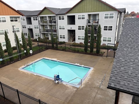 A man is sitting on the edge of a small pool.