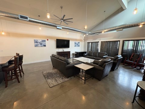 A living room with a grey couch and a television on the wall.