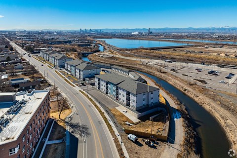 A road with a bridge over a river and a building on the right.