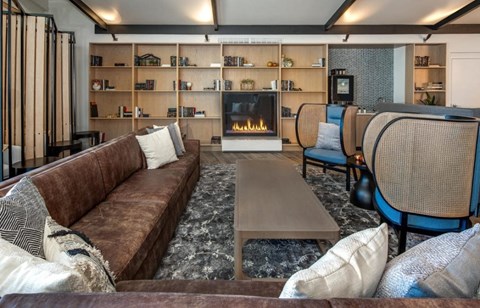 a living room with a brown couch and a fireplace