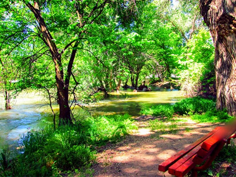 a red bench sitting next to a river