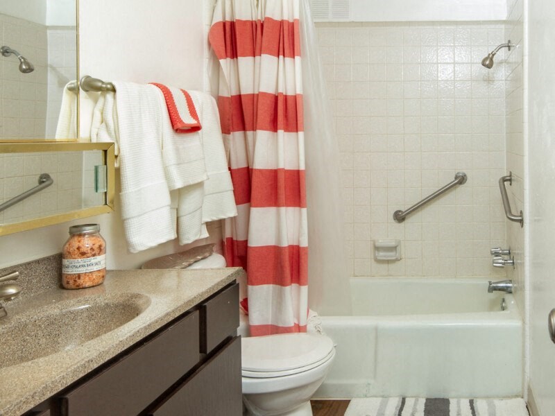 a bathroom with a red and white shower curtain