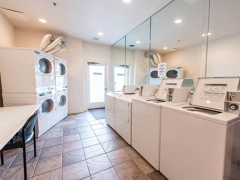 a laundry room with washers and dryers and a table with washing machines