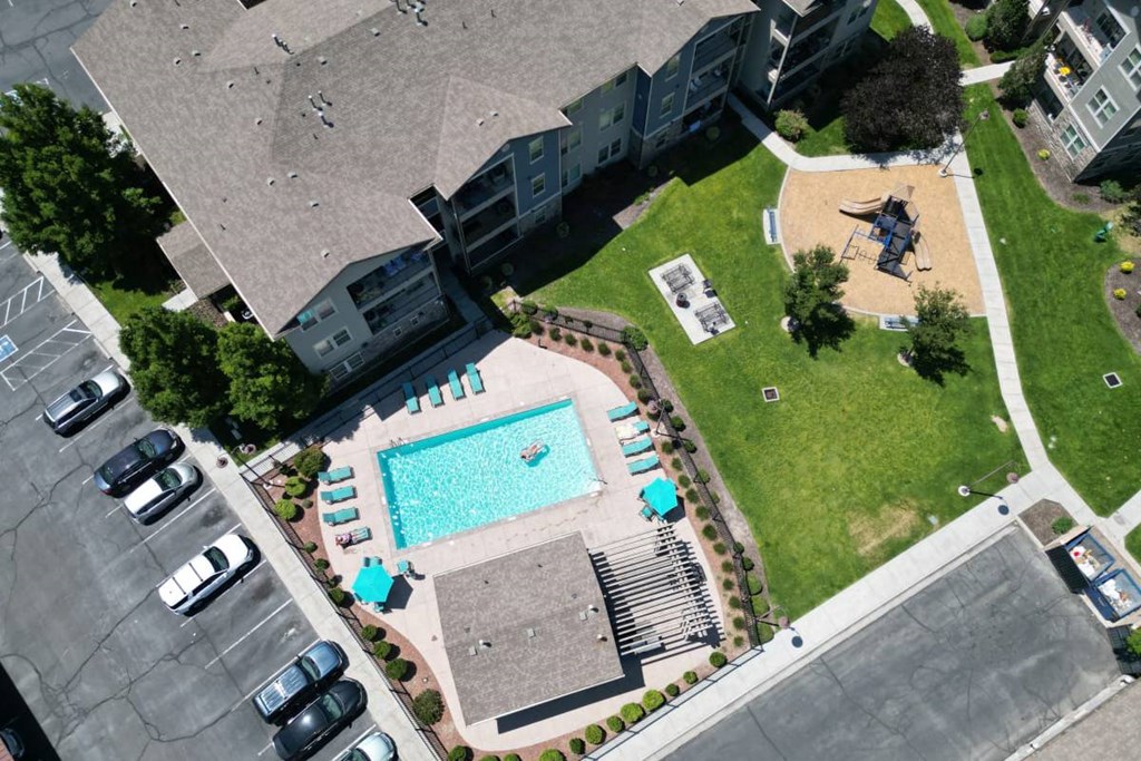 an aerial view of a swimming pool in front of an apartment building