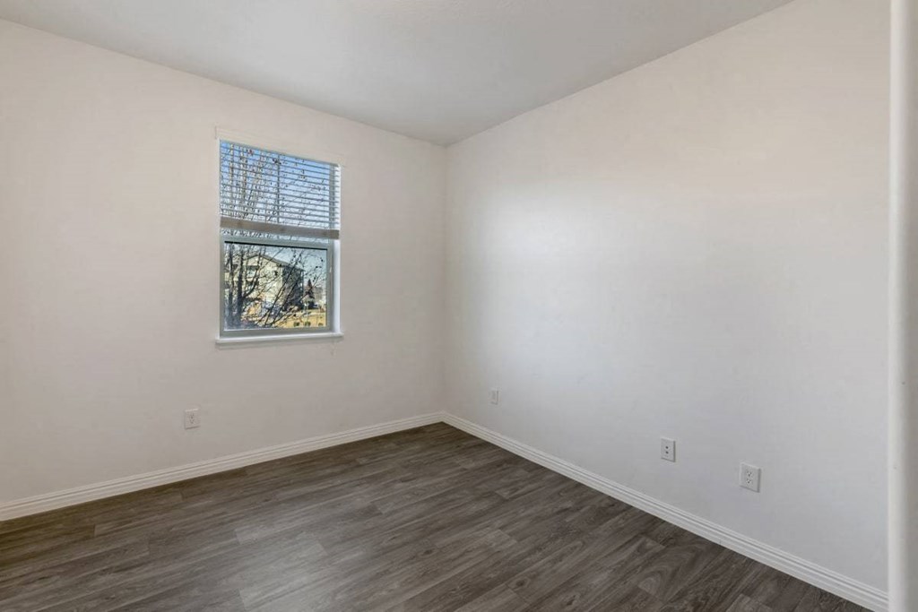 an empty room with white walls and a window