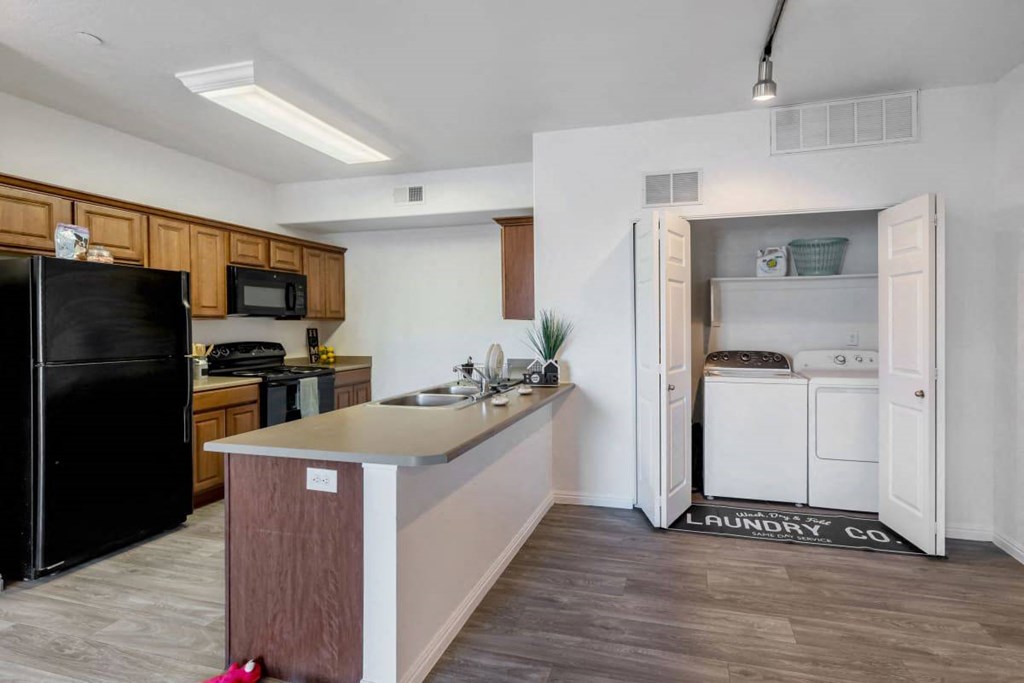 a kitchen with a counter top and a black refrigerator