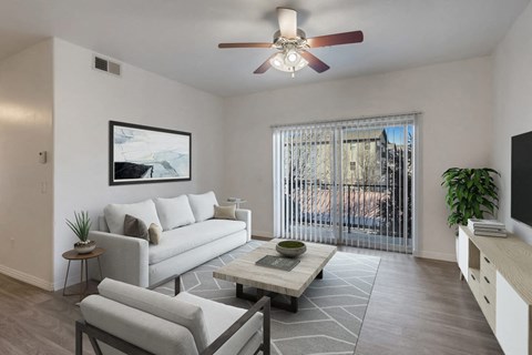 a living room with a white couch and a ceiling fan
