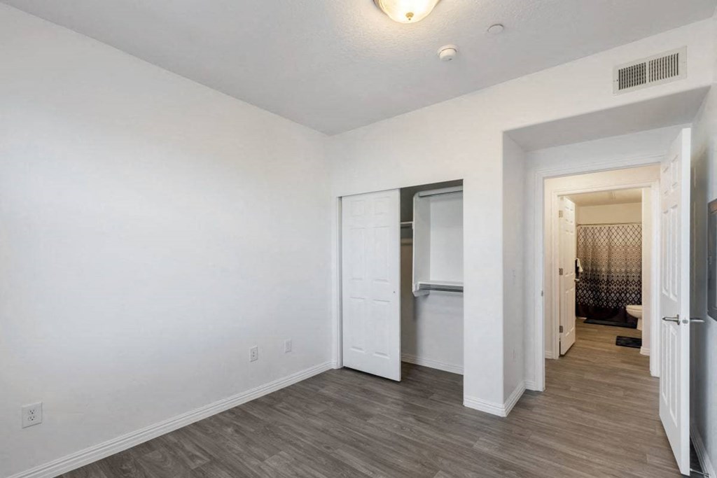 a renovated living room with white walls and a closet