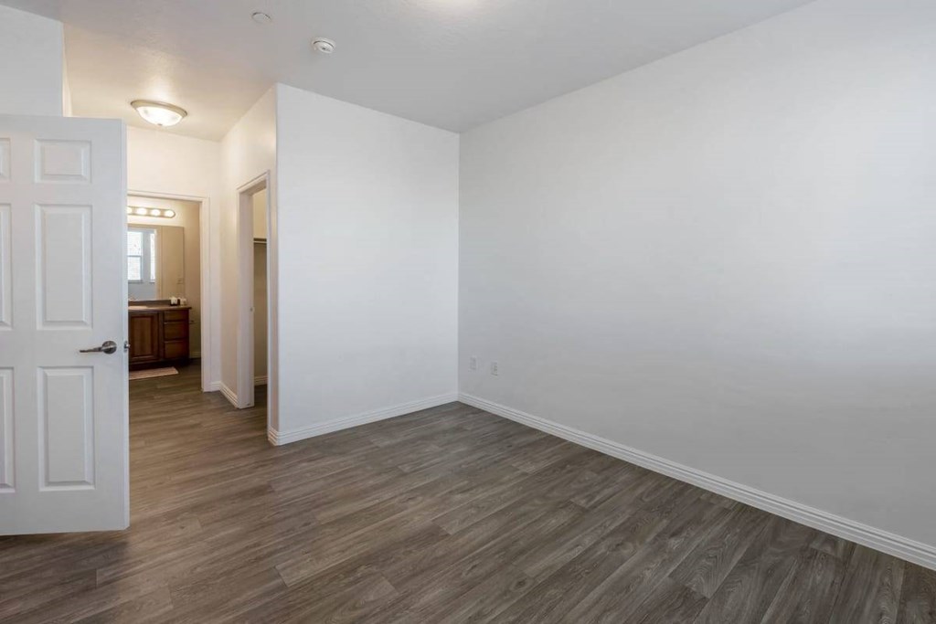 an empty living room with white walls and wood floors