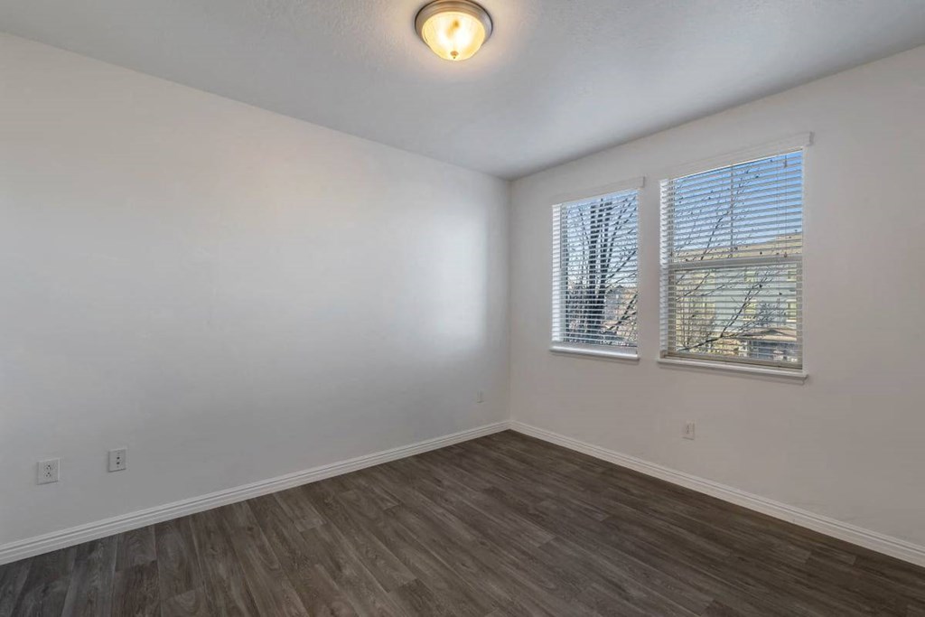 an empty living room with white walls and wood floors