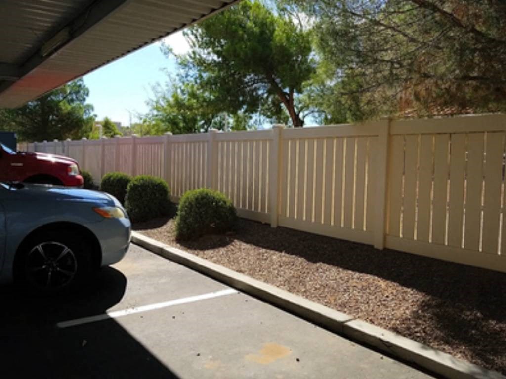 a white fence with a car parked in front of it