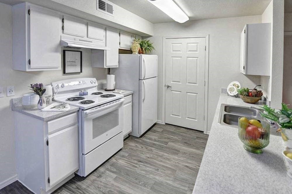 a white kitchen with white appliances and white cabinets
