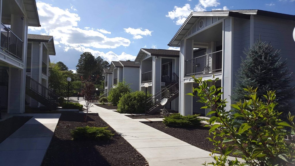 a row of houses with a sidewalk in front of them