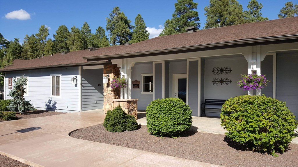 the front of a white house with a driveway and a porch