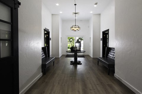 a long hallway with chairs and a table and a chandelier