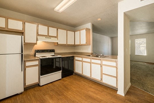 a kitchen with white cabinets and a stove and a refrigerator
