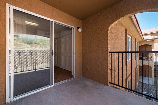 a balcony with a sliding glass door and a balcony railing