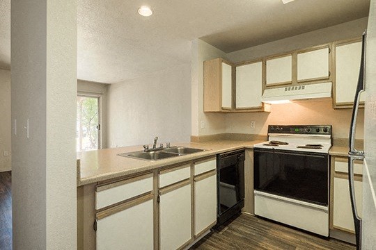 a kitchen with white cabinets and a sink and a stove