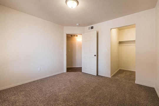 an empty living room with a door to a closet
