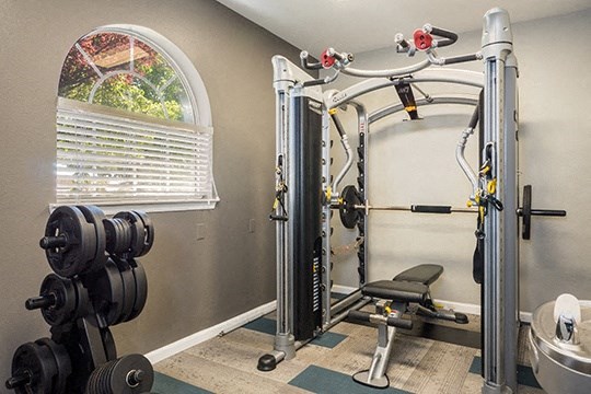 a home gym with exercise equipment and a window