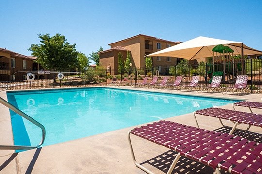a swimming pool with chairs and umbrellas at the resort