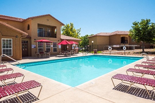 a swimming pool with lounge chairs and a resort style hotel pool