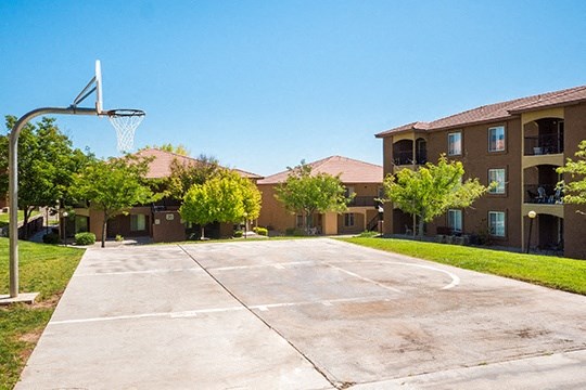 an empty basketball court in front of an apartment building