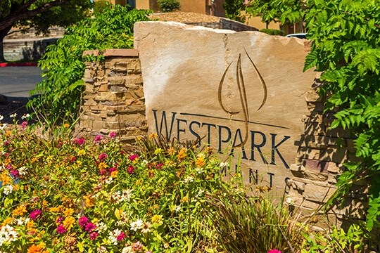 a sign in front of a garden with flowers