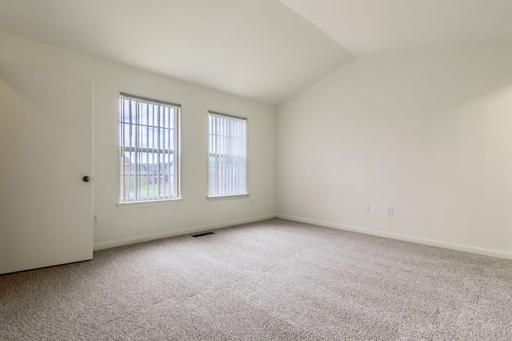 Bedroom with large windows and carpet