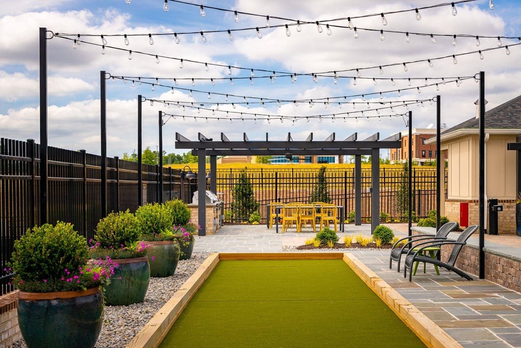 a courtyard with a table and chairs under a pergola