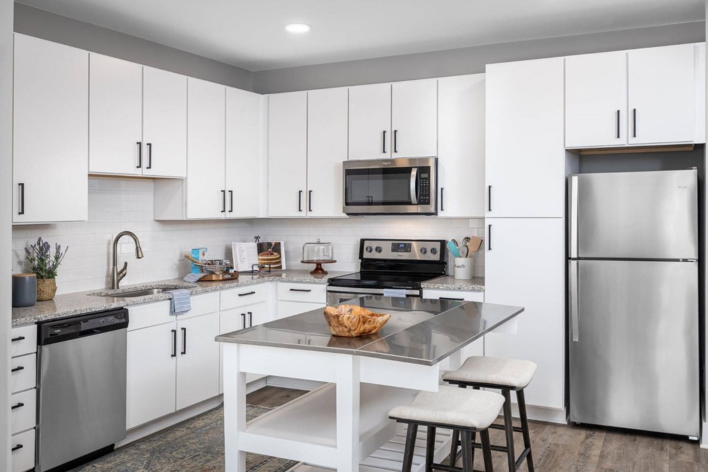 a kitchen with white cabinets and stainless steel appliances