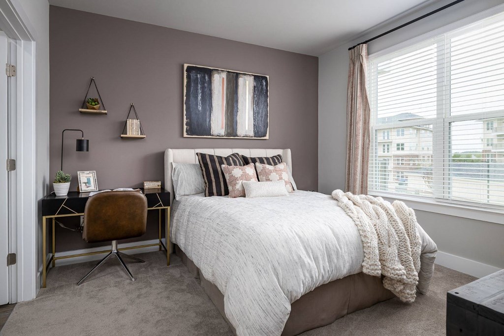 a bedroom with a bed and a desk with a chair