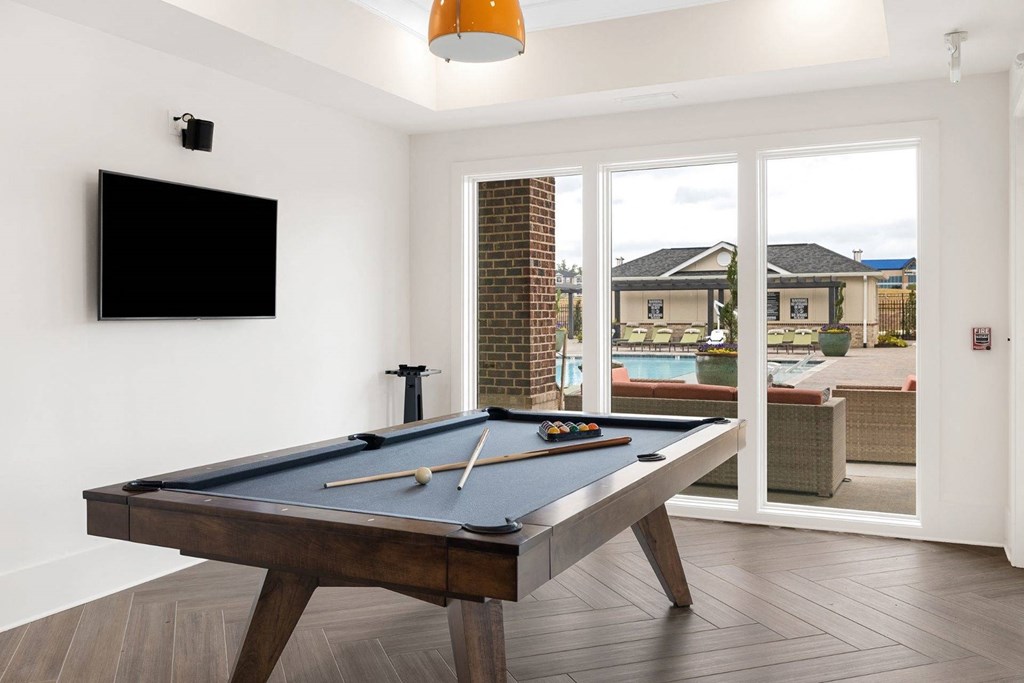 a games room with a pool table and a television