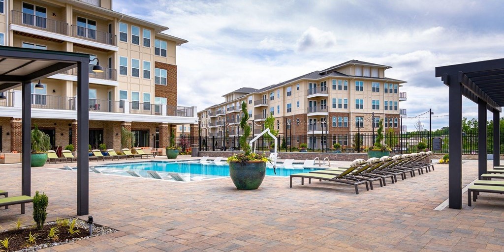 Swimming pool with lounge chairs in front of an apartment building