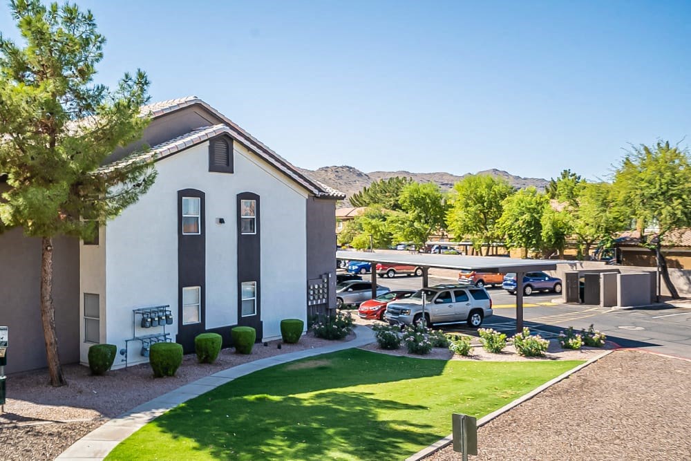 a white building with a parking lot and a lawn