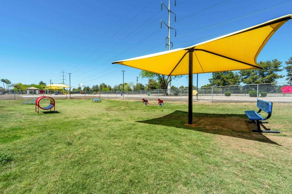 children playing in a playground with a yellow umbrella