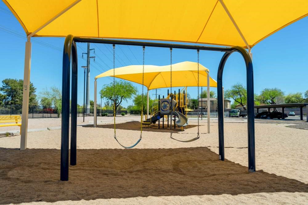 a man sitting on a swing at a playground