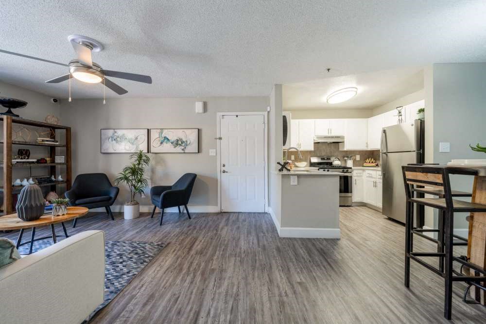 a living room and kitchen with a ceiling fan