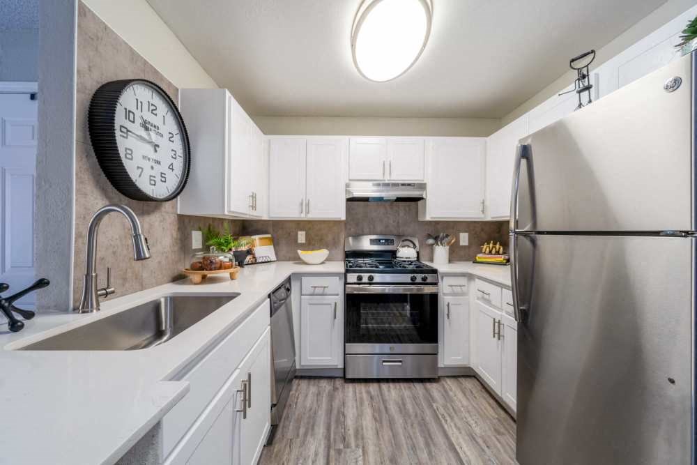 a kitchen with stainless steel appliances and a clock on the wall