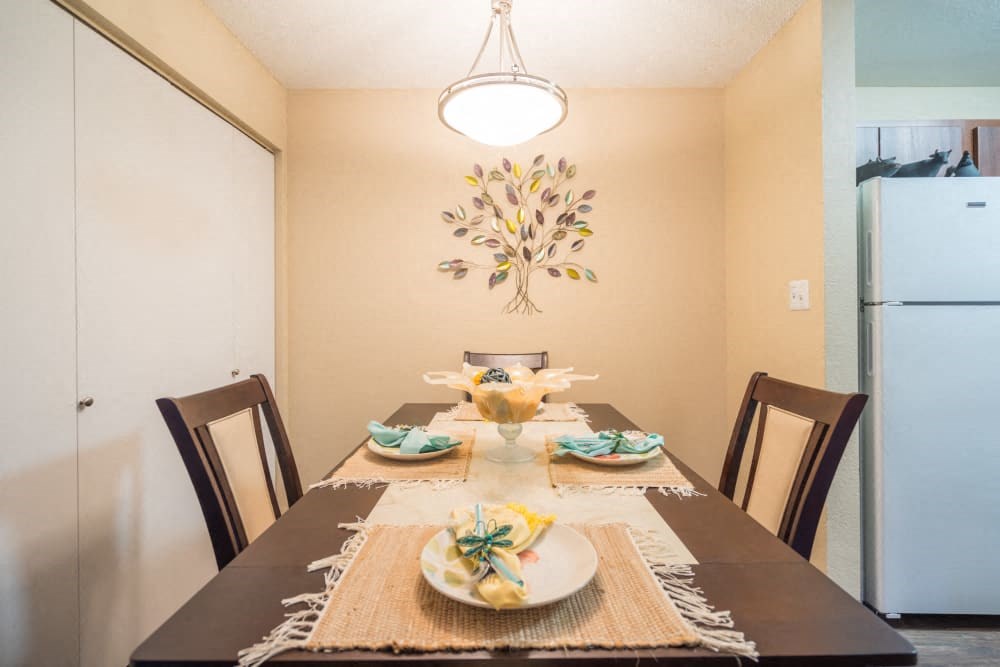 a dining room with a table and chairs and a refrigerator