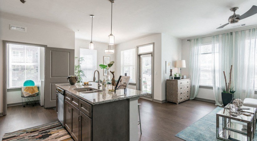 an open kitchen and living room with a large counter top