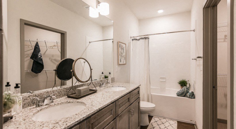 a bathroom with two sinks and a shower and a toilet