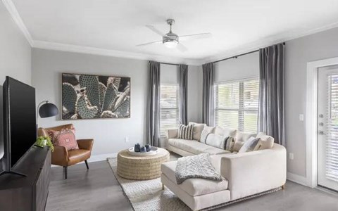 A living room with a white couch, a brown chair, and a painting on the wall.