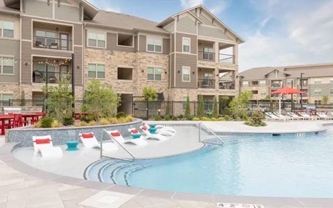 A large swimming pool in front of apartment buildings.