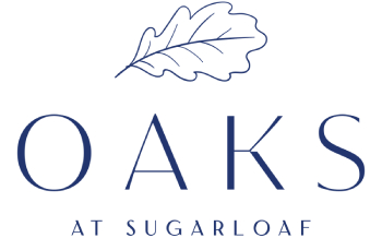 A logo with a leaf and the words "Oaks at Sugarloaf" in blue.