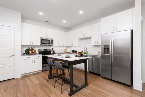 A kitchen with a table and chairs in the middle of it.