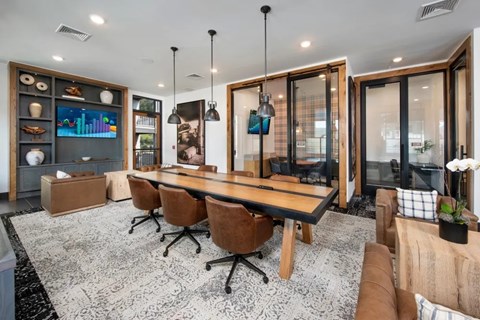A modern dining room with a long table and chairs.
